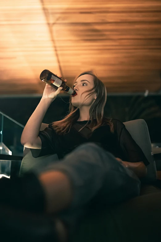 a woman sitting on a couch drinking from a bottle, pexels contest winner, renaissance, beer bottle, sydney sweeney, mid night, head tilted down