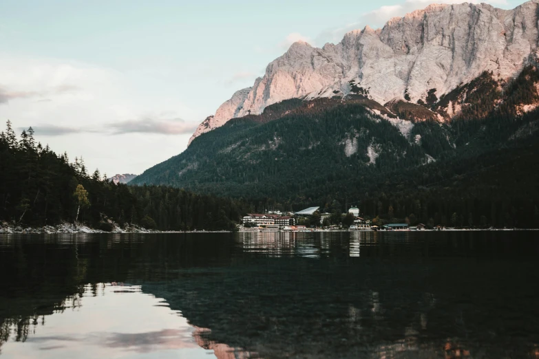 a body of water with a mountain in the background, by Sebastian Spreng, pexels contest winner, late summer evening, white marble buildings, summer lake setting, multiple stories