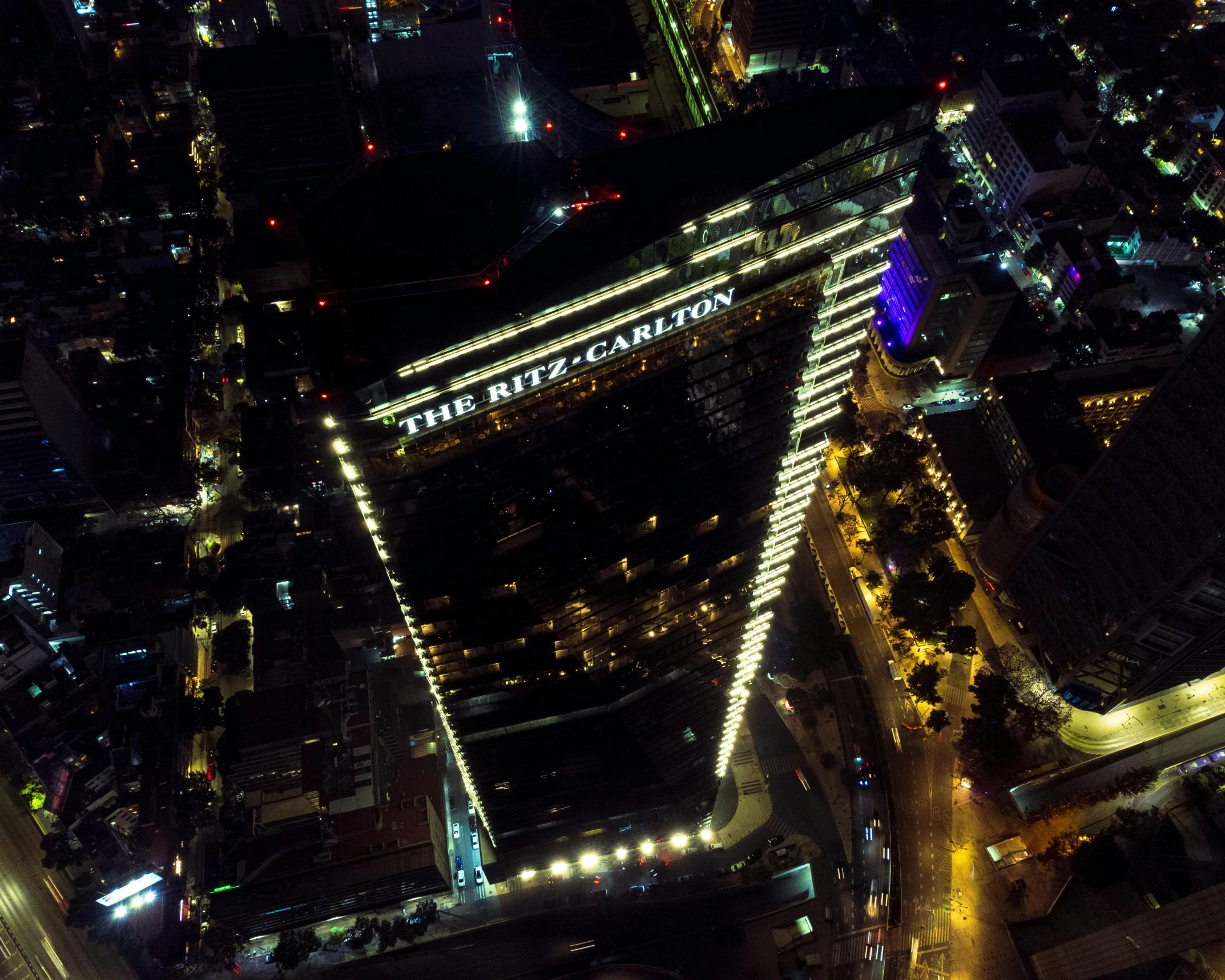 an aerial view of a city at night, an album cover, pexels contest winner, the building is a skyscraper, mexico city, profile image, zig zag