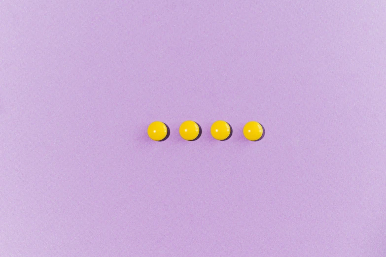 three yellow buttons sitting on top of a purple surface, a minimalist painting, inspired by Yahoo Kusama, trending on pexels, postminimalism, lilac, in a row, emitting diodes, ocd