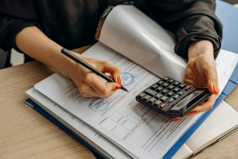 a woman that is sitting at a table with a calculator, pexels contest winner, te pae, holding a clipboard, detailed screenshot, 3 4 5 3 1