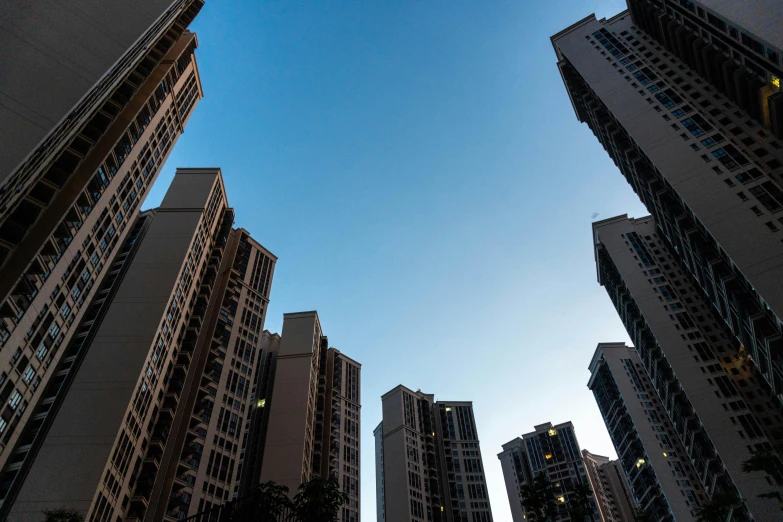 a group of tall buildings in a city, inspired by Cheng Jiasui, unsplash, hyperrealism, clear blue sky, mass housing, 2000s photo, architectural photography