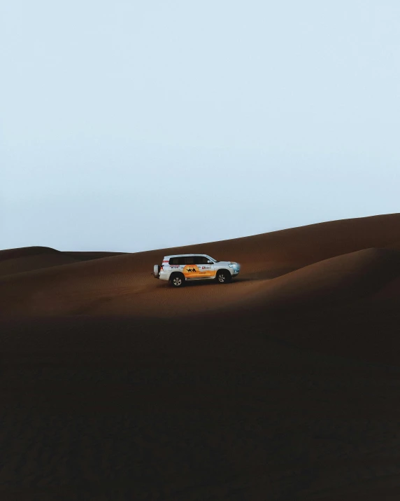 a car that is sitting in the sand, inspired by Scarlett Hooft Graafland, pexels contest winner, hurufiyya, in a vast serene landscape, dark and dusty, on a yellow canva, gif