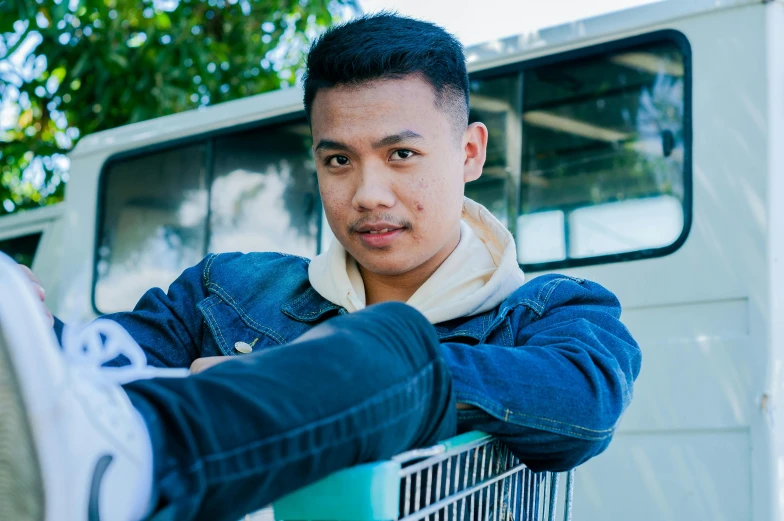 a man sitting on top of a shopping cart, a portrait, inspired by Eddie Mendoza, pexels contest winner, looking to camera, hoang lap, he is about 20 years old | short, headshot profile picture