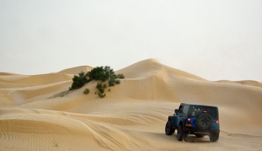 a jeep driving through the sand dunes in the desert, light tan, blue sand, detailing, mechanics