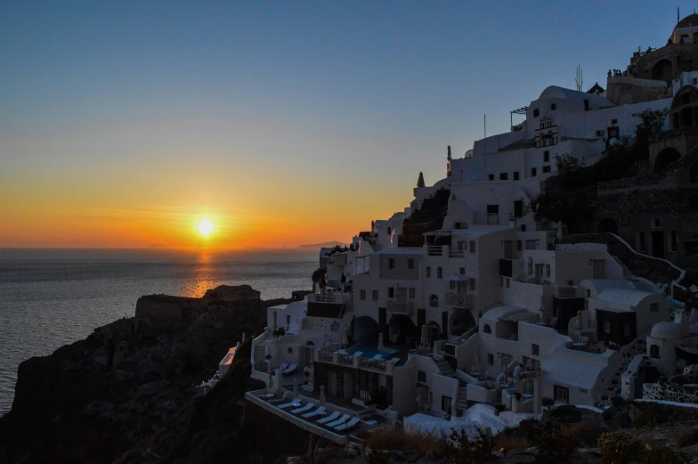 the sun is setting over the village of oia, pexels contest winner, slide show, white, journalism photo