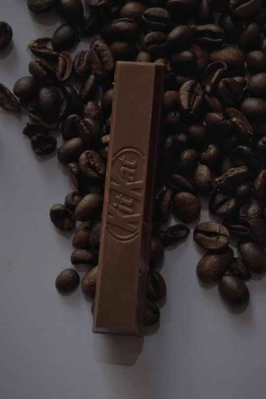 a bar of chocolate sitting on top of a pile of coffee beans, inspired by Jan Müller, really long, slayer, hey, product image