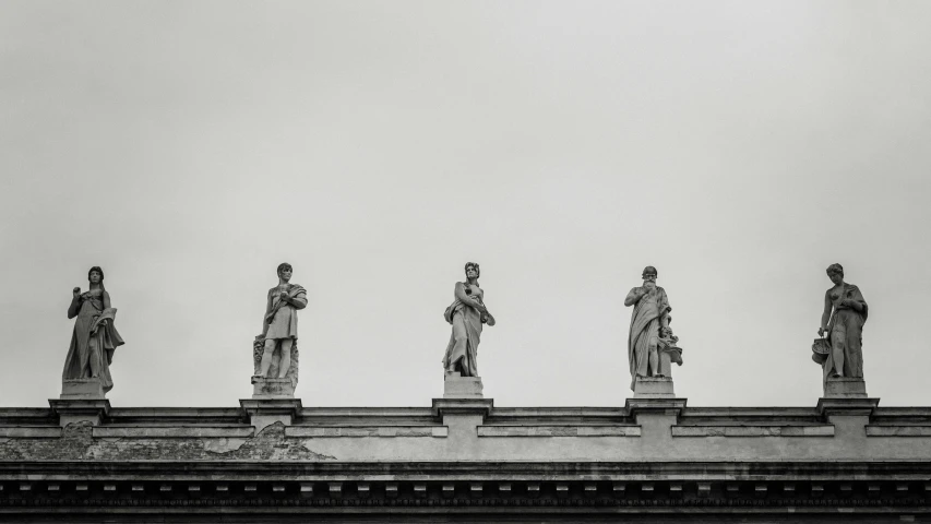 a black and white photo of statues on top of a building, by Matthijs Naiveu, unsplash contest winner, neoclassicism, the three fates, dressed in roman clothes, minimalist photo, library of congress