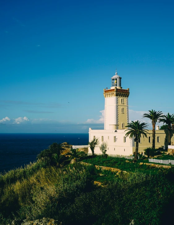 a lighthouse sitting on top of a hill next to the ocean, les nabis, moorish architecture, fan favorite, how pretty, thumbnail