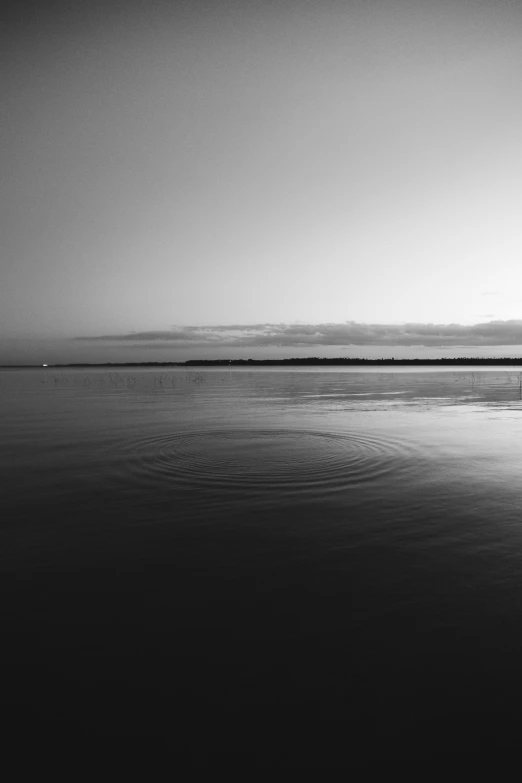 a black and white photo of the ocean, inspired by Max Dupain, unsplash, minimalism, wide river and lake, morning golden hour, rounded lines, an eerie whirlpool