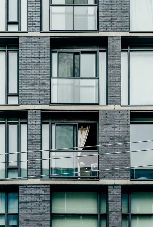 a tall building with lots of windows and balconies, a portrait, by Harvey Quaytman, unsplash, modernism, slate, dwell, steel window mullions, ten flats