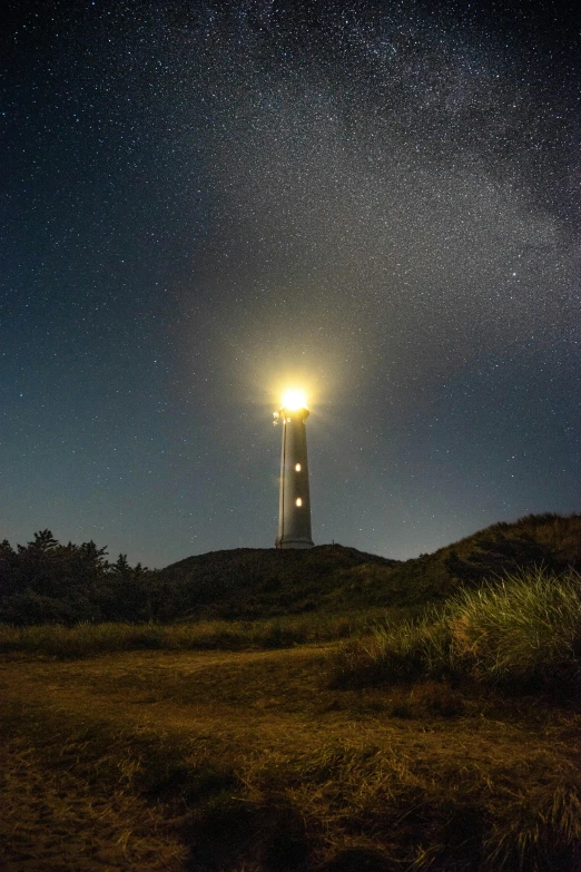 a light house sitting on top of a hill under a night sky, by Jacob Toorenvliet, light and space, full frame image, multiple lights, medium, 8k resolution”