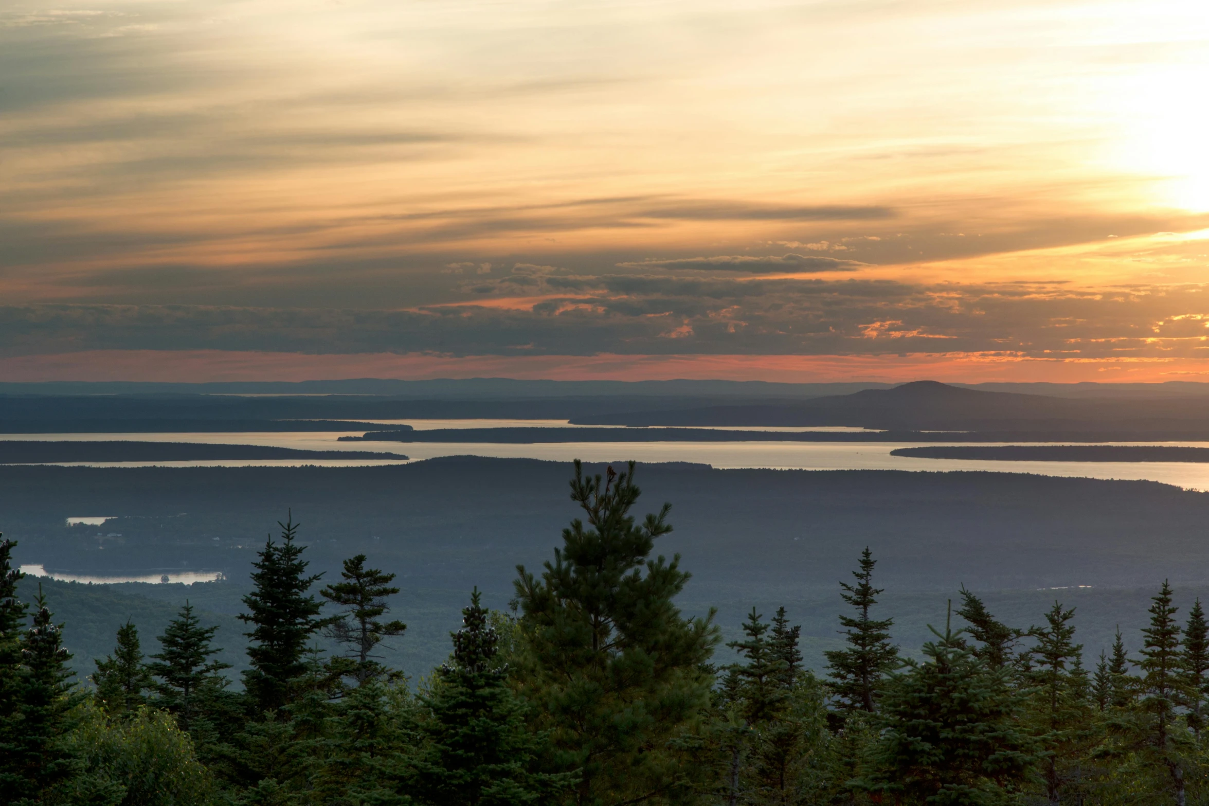 a person riding a snowboard on top of a mountain, by Meredith Dillman, trending on unsplash, hudson river school, sunset panorama, hemlocks, view of the ocean, new hampshire