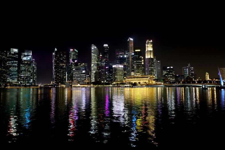 a view of a city at night from across the water, a picture, the singapore skyline, highly reflective, youtube thumbnail, night time footage