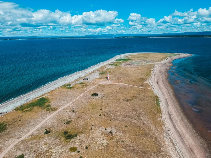 an aerial view of a beach and a body of water, by Jesper Knudsen, pexels contest winner, land art, lake baikal in the background, a road leading to the lighthouse, thumbnail, listing image