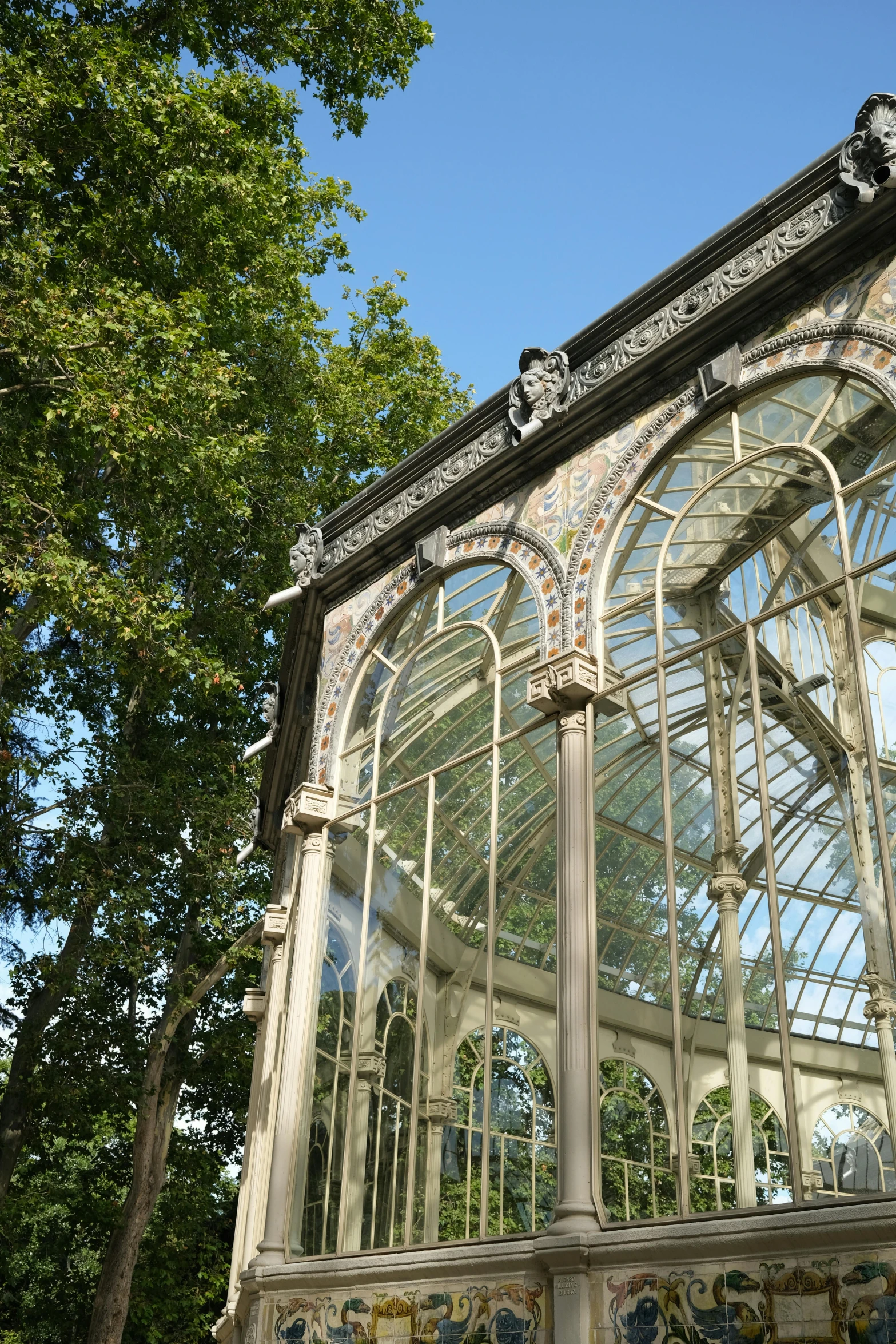 a large glass building sitting in the middle of a park, inspired by Luis Paret y Alcazar, art nouveau, greenhouse, black rococo, verdigris, caparisons