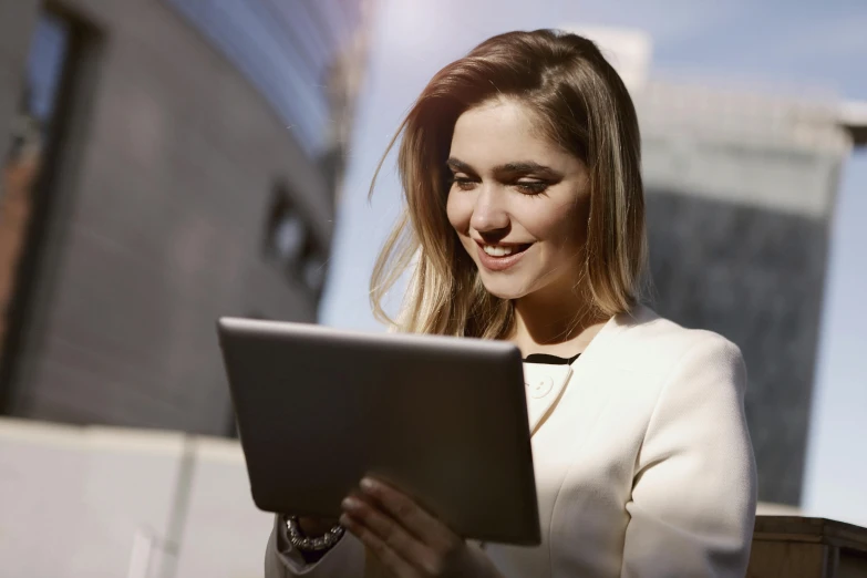 a woman sitting on a bench using a tablet computer, a portrait, trending on unsplash, elegant light, low - angle shot, ad image, thumbnail