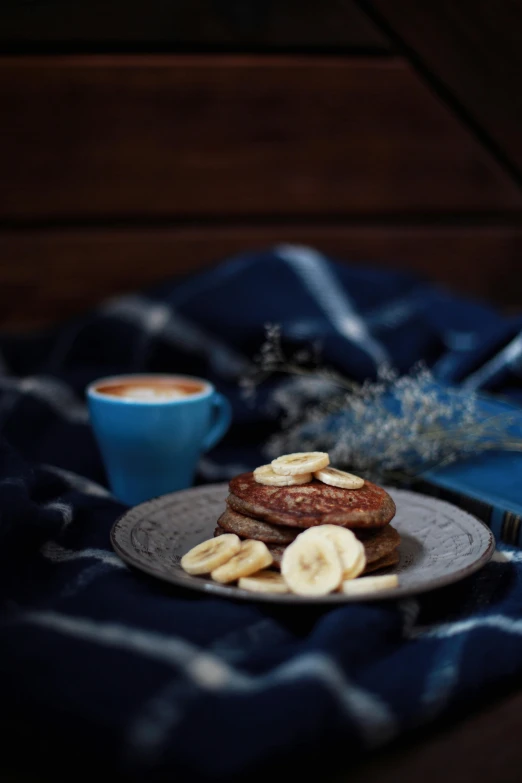 a plate of pancakes with banana slices and a cup of coffee, a still life, unsplash, romanticism, gif, bl, full frame image