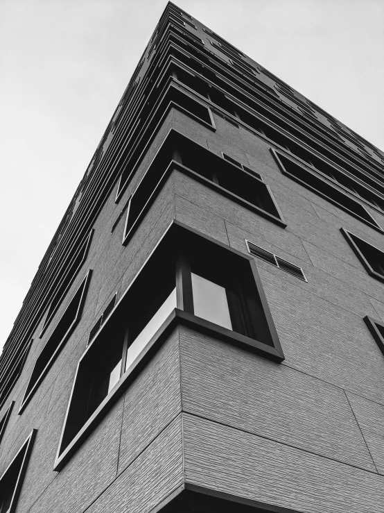 a black and white photo of a tall building, a black and white photo, inspired by David Chipperfield, unsplash, low angle!!!!, square jaw-line, low dutch angle, window