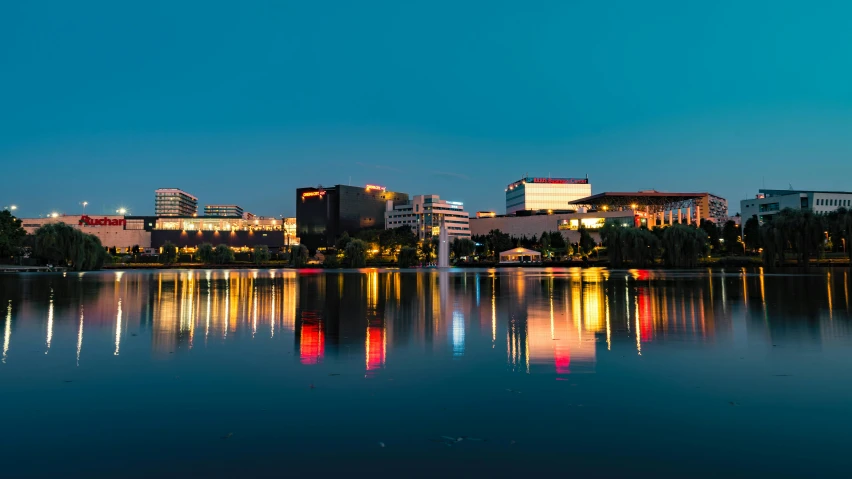 a large body of water with buildings in the background, by Washington Allston, pexels contest winner, hurufiyya, lakeside, lit from the side, full-color, crisp detail