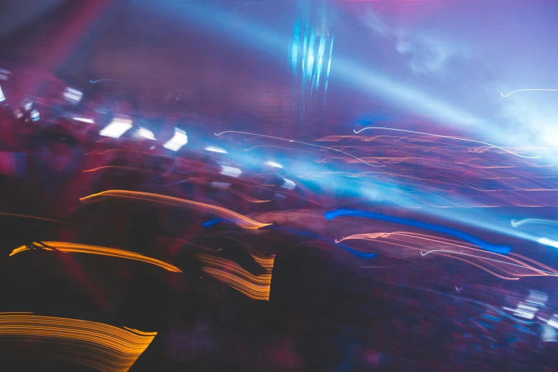 a crowd of people sitting in front of a stage, a picture, by Adam Marczyński, pexels contest winner, lyrical abstraction, car lights, purple and blue neon, driving fast, photo of futuristic cityscape