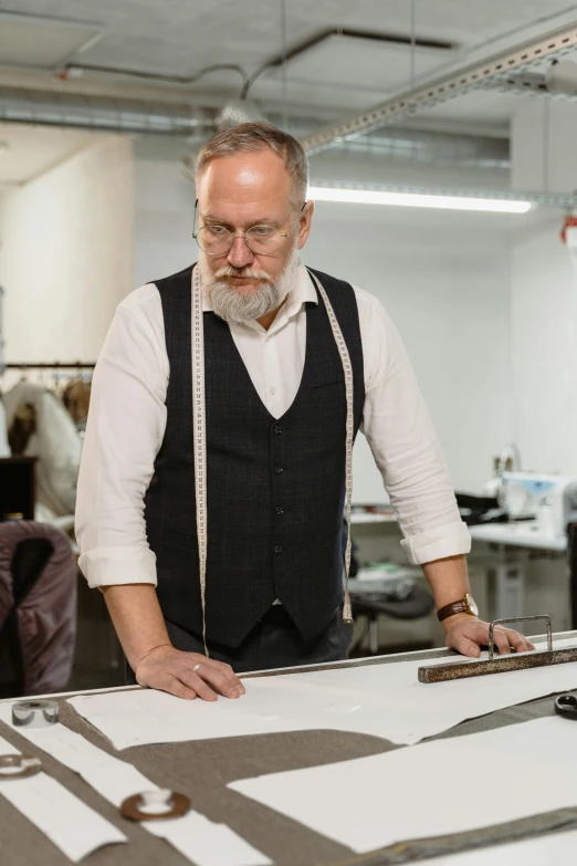 a man that is standing in front of a table, a silk screen, leather clothing, expert design, wearing a vest, ash thorp