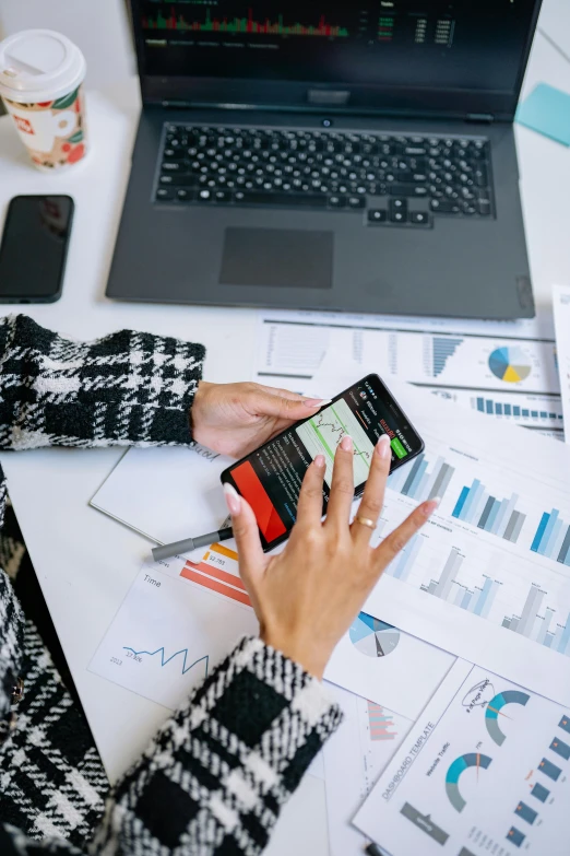 a woman sitting at a desk with a laptop and cell phone, a picture, trending on pexels, analytical art, power bi dashboard, thumbnail, ( 3 1, smart textiles