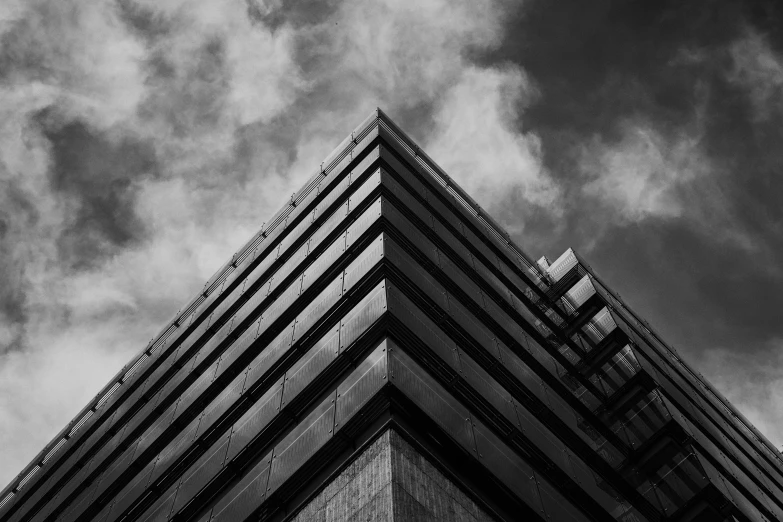 a black and white photo of a tall building, by Adam Rex, unsplash contest winner, brutalism, in triangular formation, dark towering clouds, square, low detailed
