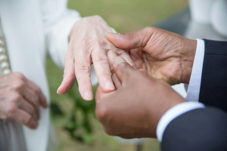 a close up of a person putting a wedding ring on another person's finger, a photo, by Dan Frazier, renaissance, varying ethnicities, 15081959 21121991 01012000 4k, high-resolution photo, commissioned