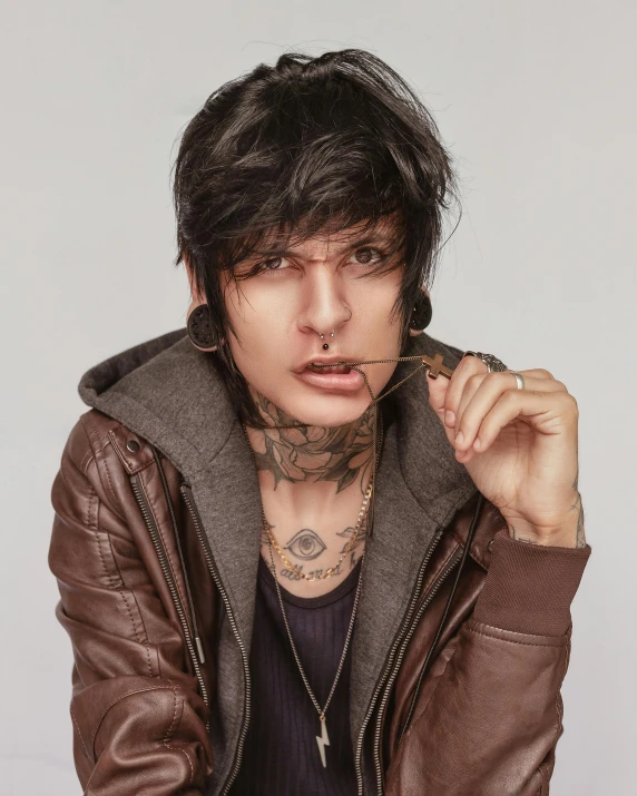 a close up of a person wearing a jacket, an album cover, inspired by Cam Sykes, androgynous face, tattoos, blank stare”, trending photo