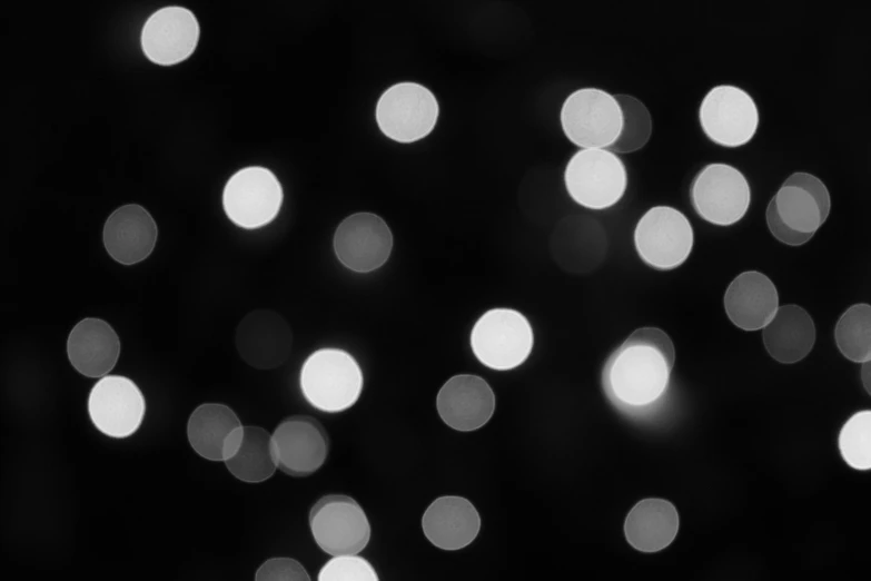 a black and white photo of a christmas tree, a black and white photo, pexels, minimalism, neon glow soft bokeh, varying dots, black!!!!! background, 4 5 mm bokeh