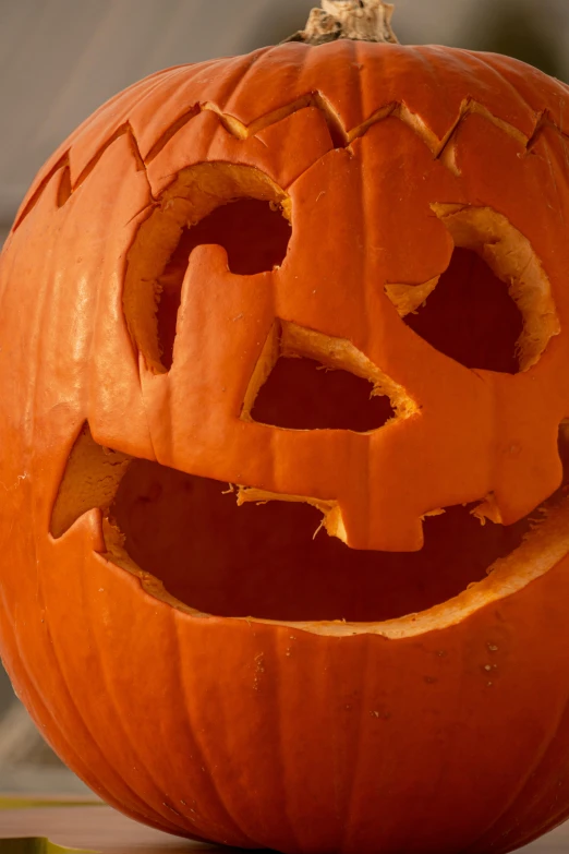 a carved pumpkin sitting on top of a table, close up of face, 2 5 6 x 2 5 6 pixels, fan favorite, grinning