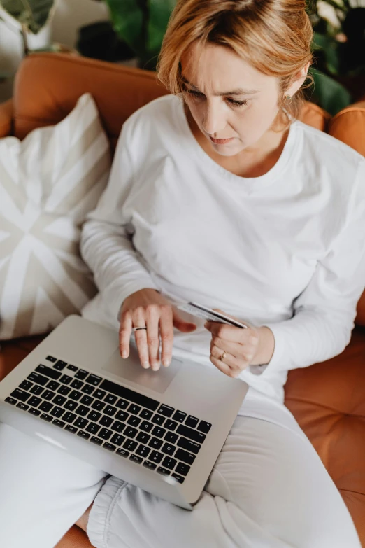 a woman sitting on a couch using a laptop, pexels contest winner, renaissance, wearing a white sweater, at checkout, thumbnail, ( 3 1