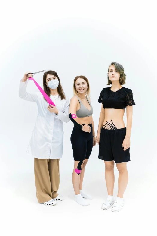 a group of three women standing next to each other, a colorized photo, by Adam Marczyński, pexels contest winner, wearing bionic implants, with a white background, sport clothing, with wires and bandages