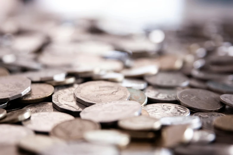 a pile of coins sitting on top of a table, gleaming silver, thumbnail, shallow depth of fielf, mixed art