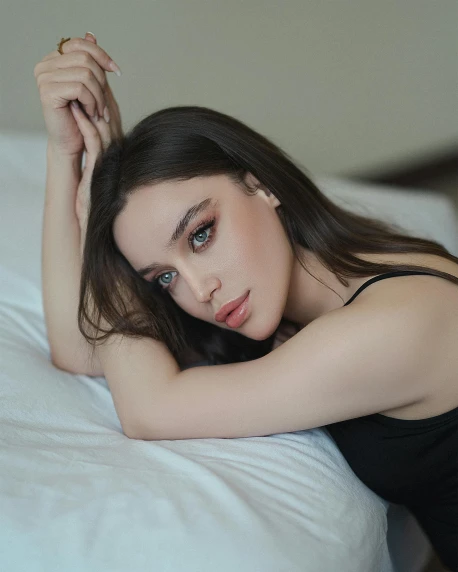 a beautiful young woman laying on top of a bed, a colorized photo, trending on pexels, hurufiyya, big cheekbones, bella poarch, confident looking, luts