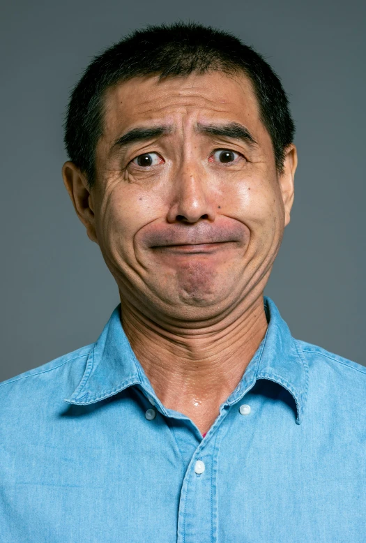 a man in a blue shirt posing for a picture, inspired by Martin Schoeller, reddit, shin hanga, crying eyes closed!, ernie chan, plain background, high resolution photo