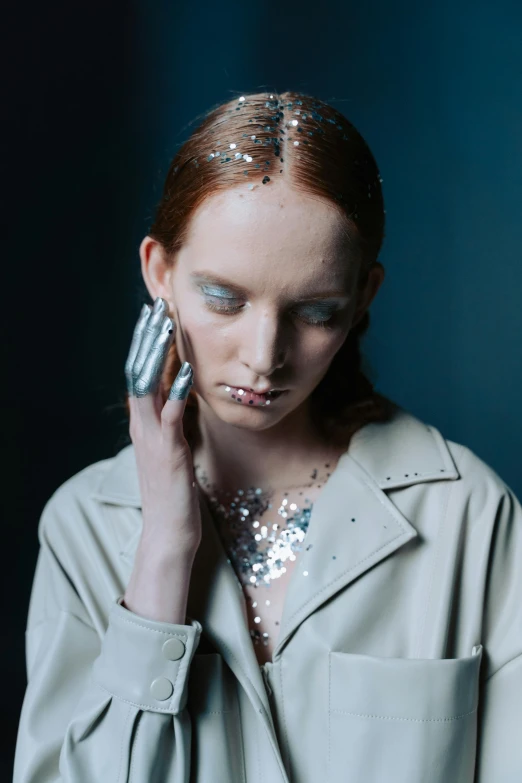 a woman holding a cell phone to her ear, a portrait, inspired by Emma Andijewska, trending on pexels, renaissance, silver space suit, at a fashion shoot, freckled pale skin, white and teal metallic accents