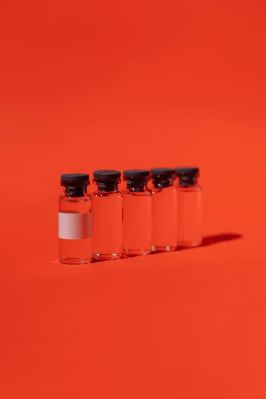 a row of vials sitting on top of a red surface, trending on pexels, extremely clean lines, instagram post, medical labels, agent orange