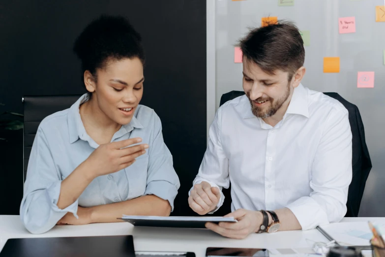 a man and a woman sitting at a desk looking at a tablet, pexels contest winner, te pae, official screenshot, professional profile picture, language