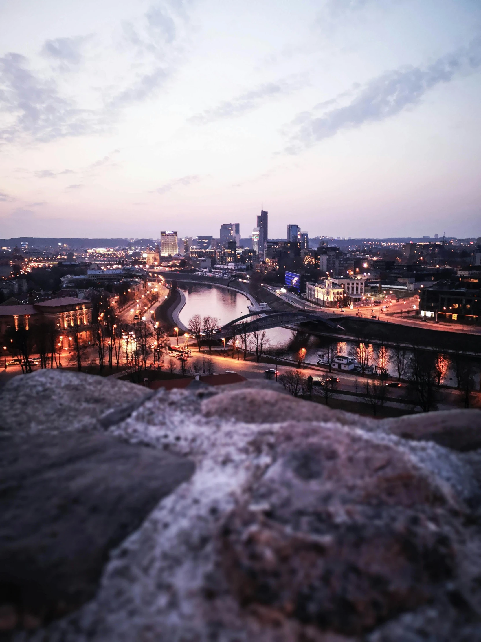 a view of a city from the top of a hill, by Greg Rutkowski, pexels contest winner, cliff side at dusk, khreschatyk, paisley, low quality photo