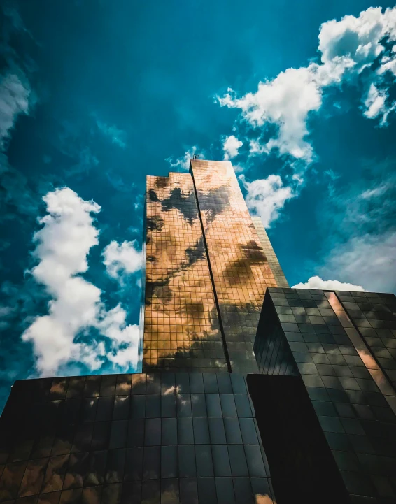 a tall building with a blue sky in the background, pexels contest winner, golden clouds, metallic reflections, thumbnail, trending on vsco