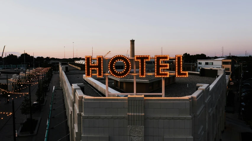 a hotel sign on the roof of a building, by Carey Morris, unsplash contest winner, graffiti, evenly lit, clemens ascher, celebration, terminal