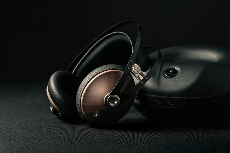 a pair of headphones sitting on top of a black surface, renaissance, metallic bronze skin, meze audio, clear [bronze] face, woodpunk