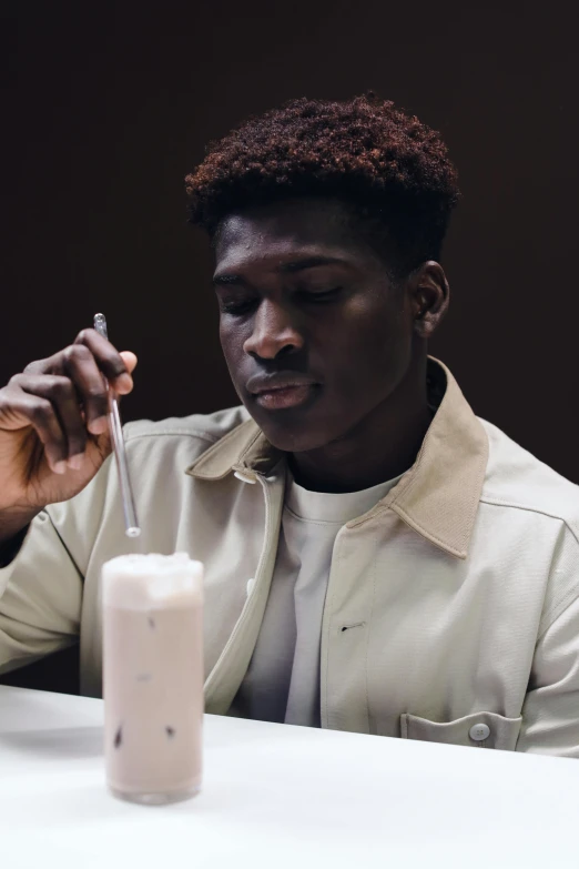 a man sitting at a table with a glass of milk, dark skinned, gen z, milkshake, ignant