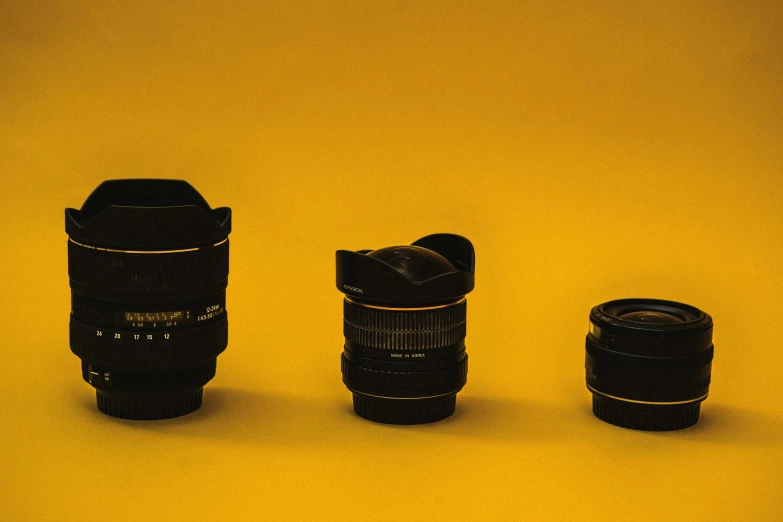 a couple of camera lenses sitting next to each other, by Adam Marczyński, pexels contest winner, photorealism, futuristic yellow lens, minimalist photo, sigma 1 0 - 2 0 mm, panoramic photography