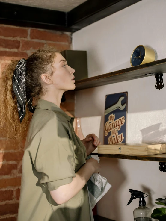 a woman standing in a kitchen next to a brick wall, a colorized photo, by Andrew Stevovich, trending on unsplash, arts and crafts movement, standing on a shelf, portrait of a mechanical girl, inspect in inventory image, queer woman