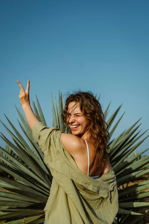 a woman standing in front of a large plant, pexels contest winner, having fun in the sun, beautiful tan mexican woman, arms out, avatar image