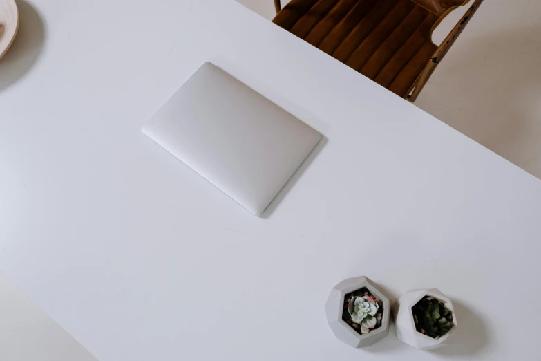 a laptop computer sitting on top of a white table, by Andries Stock, minimalism, silver，ivory, overview, tabletop, matte white paint