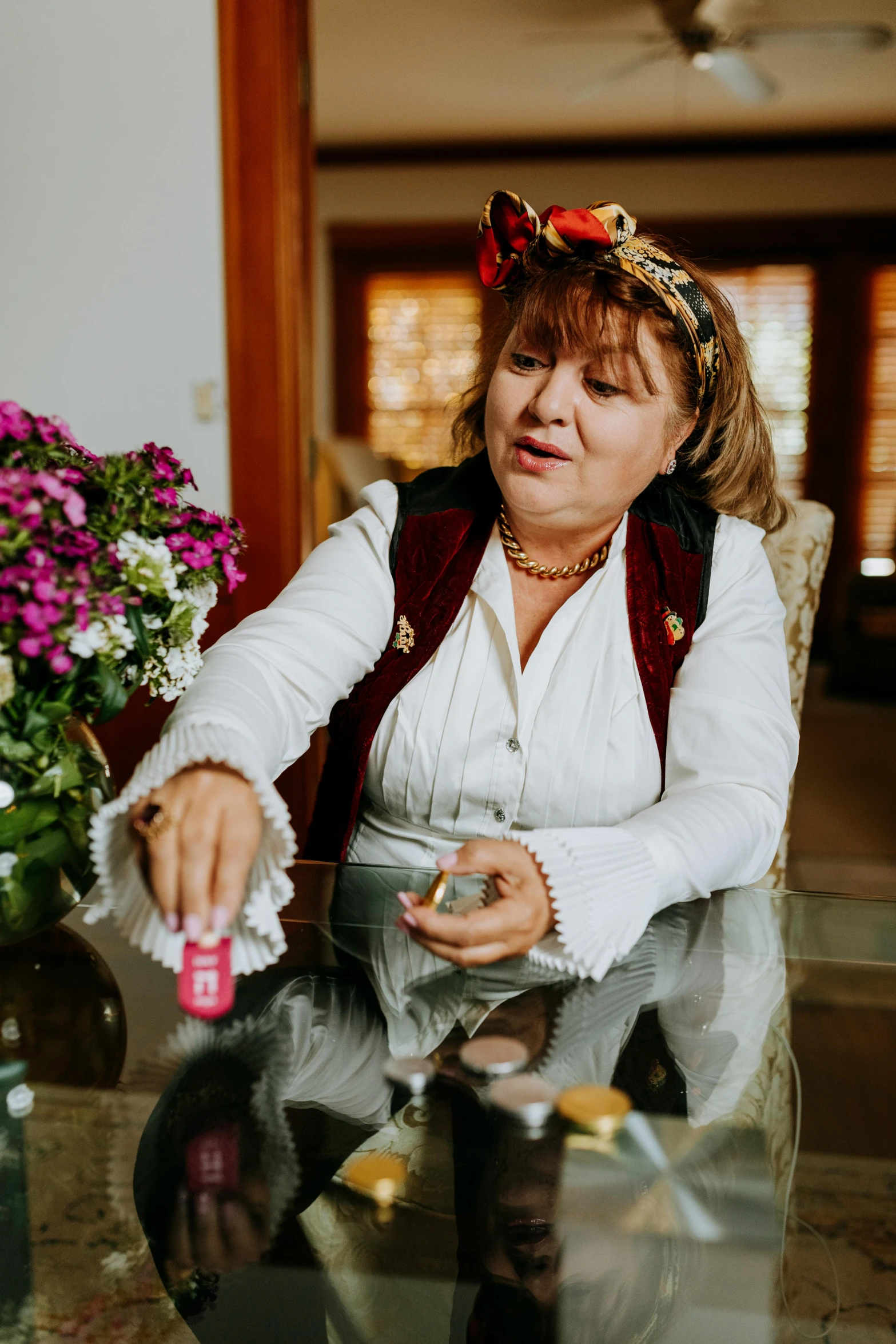 a woman sitting in a chair next to a vase of flowers, traditional romanian clothing, drinking cough syrup, candy treatments, putting makeup on